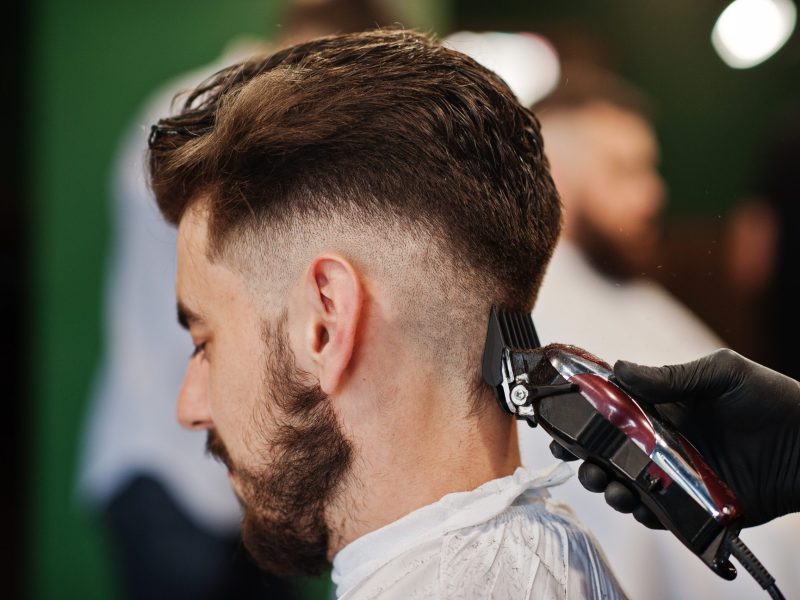 Handsome bearded man at the barbershop, barber at work