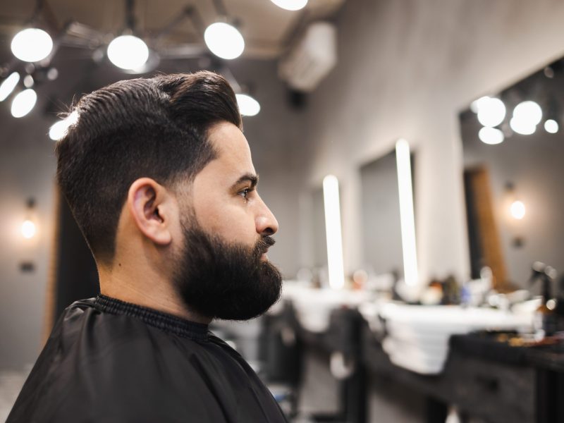 Bearded man sitting on barbershop chair